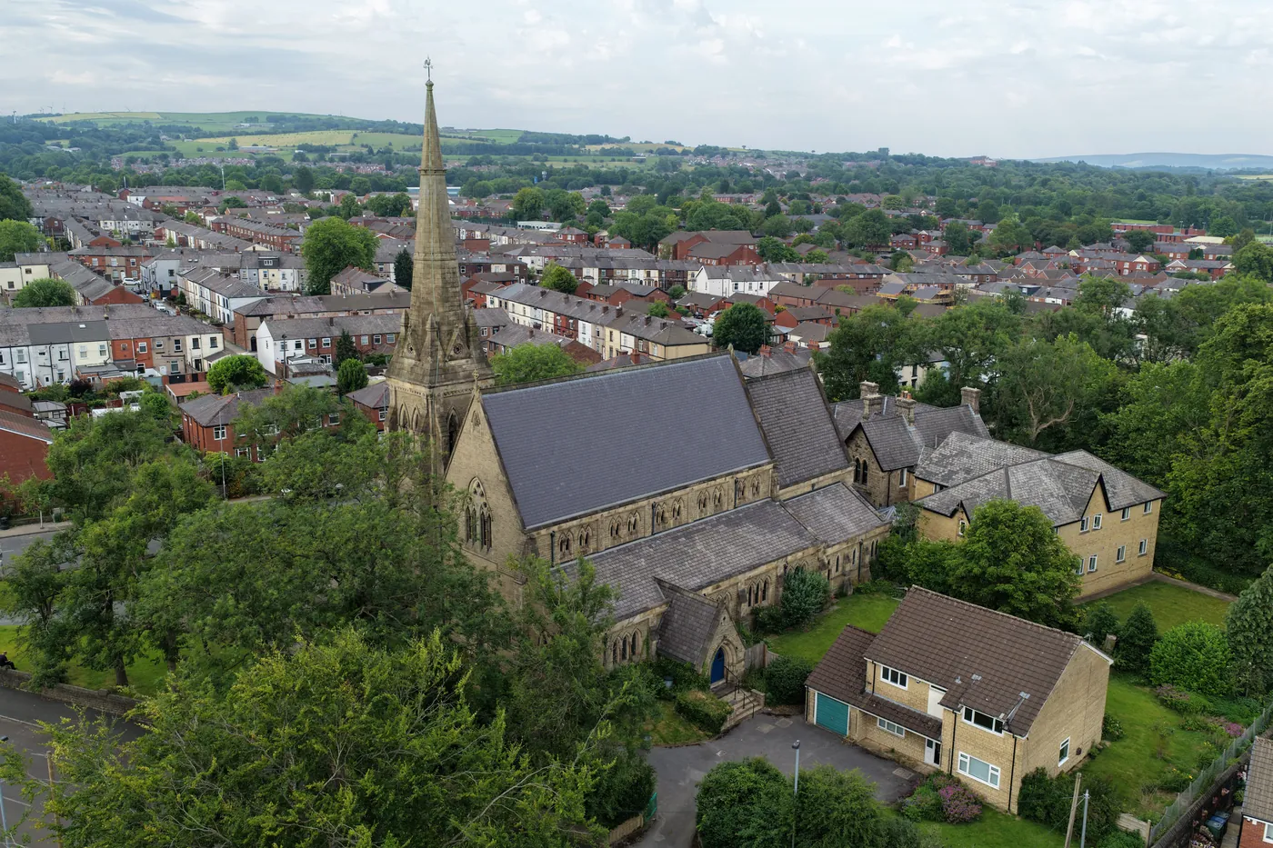 St Thomas seen from the air amid terraced streets, with the Lancashire moors on the horizon