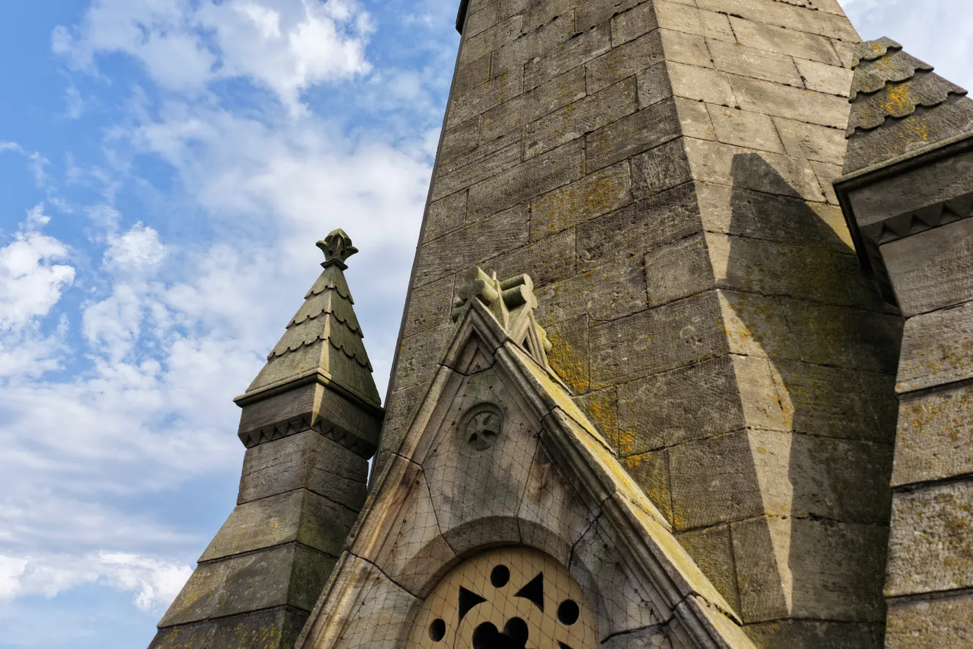 A carved stone figure set at the foot of the spire, far above head height