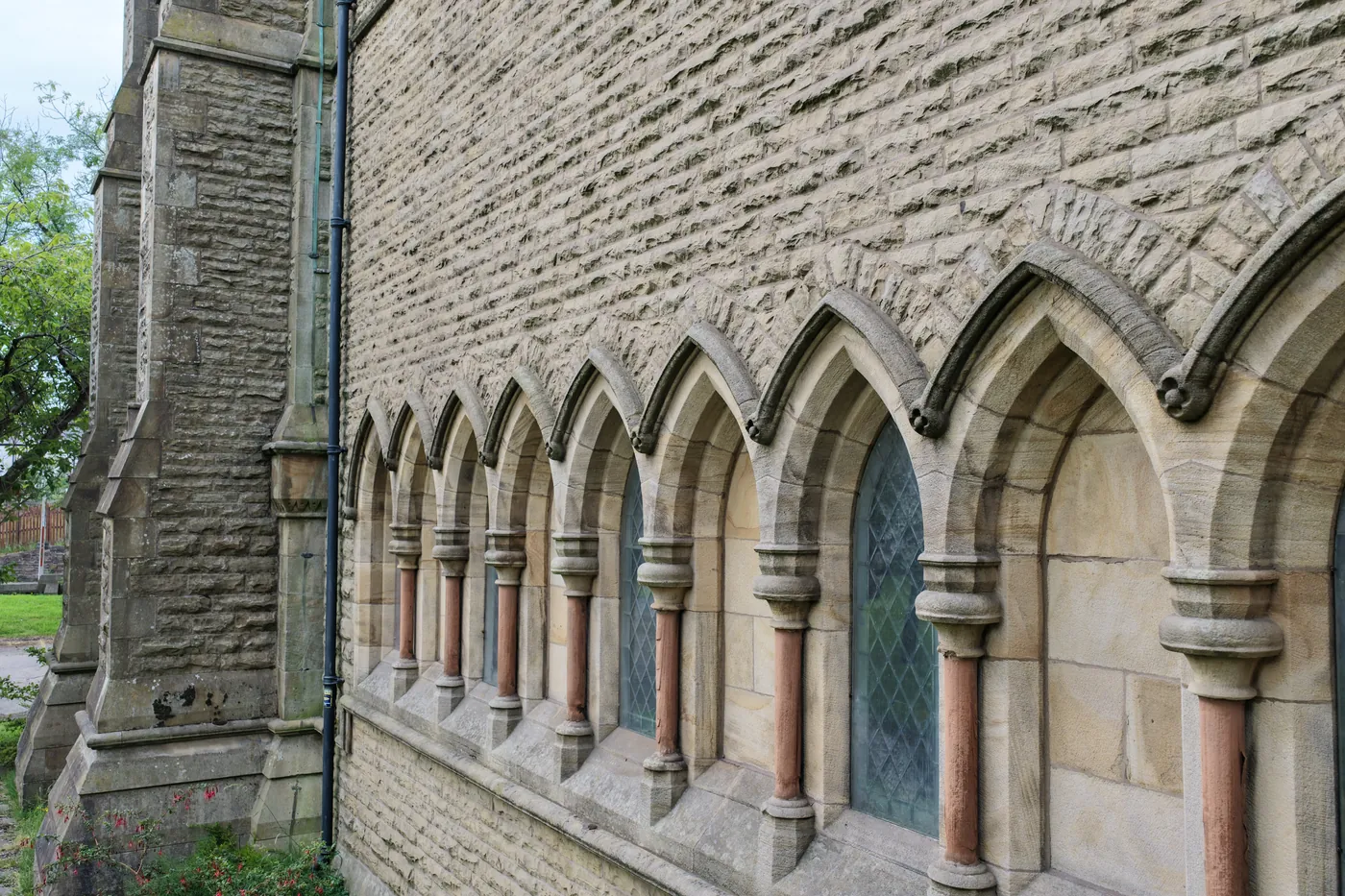 A run of arcaded lancet windows with polished stone shafts along the outer wall