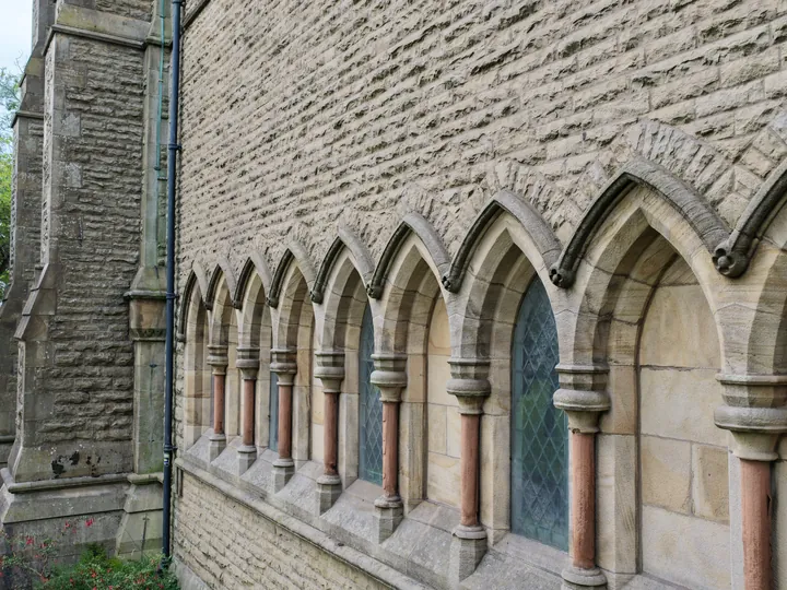 A run of arcaded lancet windows with polished stone shafts along the outer wall