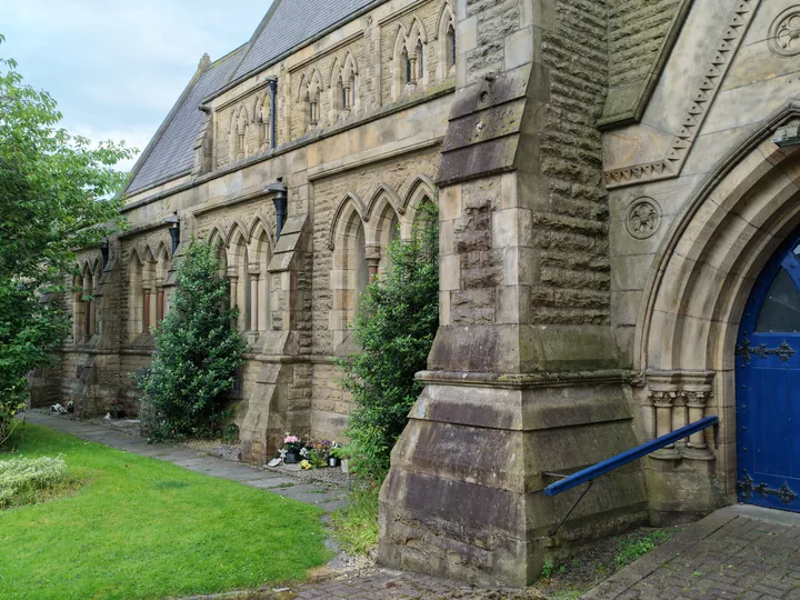 The buttressed south side of the church leading towards the entrance porch