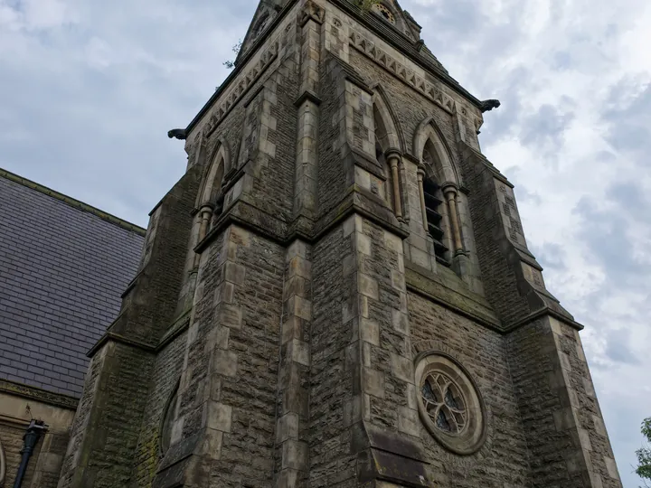 The tower of St Thomas from directly beneath, showing the rose window and louvred belfry