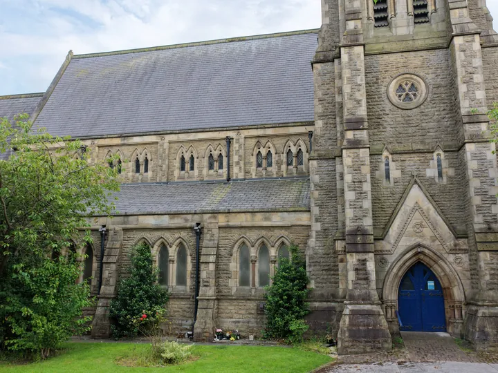 The full south elevation of St Thomas: nave, clerestory, tower and blue door