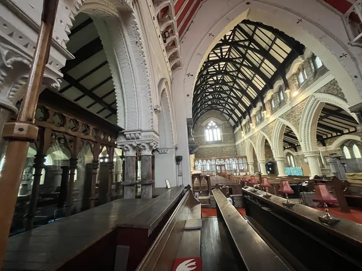 View along the church interior beneath timber roof trusses