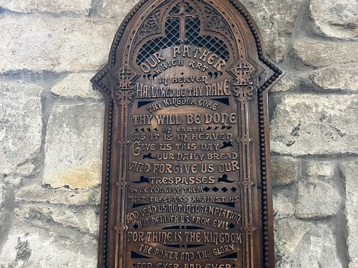 Historic memorial plaque mounted on the church stonework
