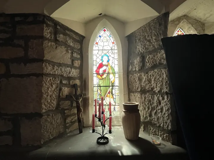 Single stained-glass figure illuminated in a stone recess