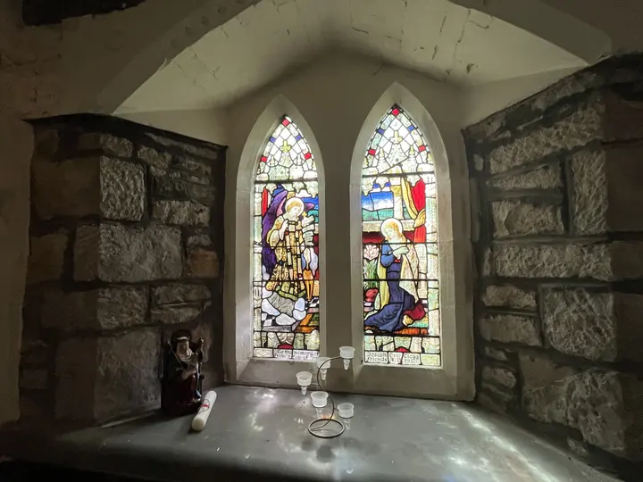 Paired stained-glass windows above a stone sill