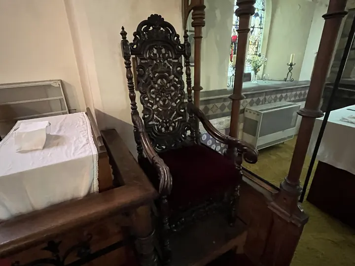 Ornately carved ceremonial chair beside the sanctuary