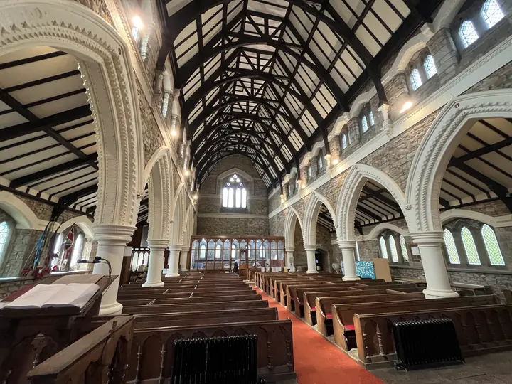 View down the nave beneath black and white timber trusses